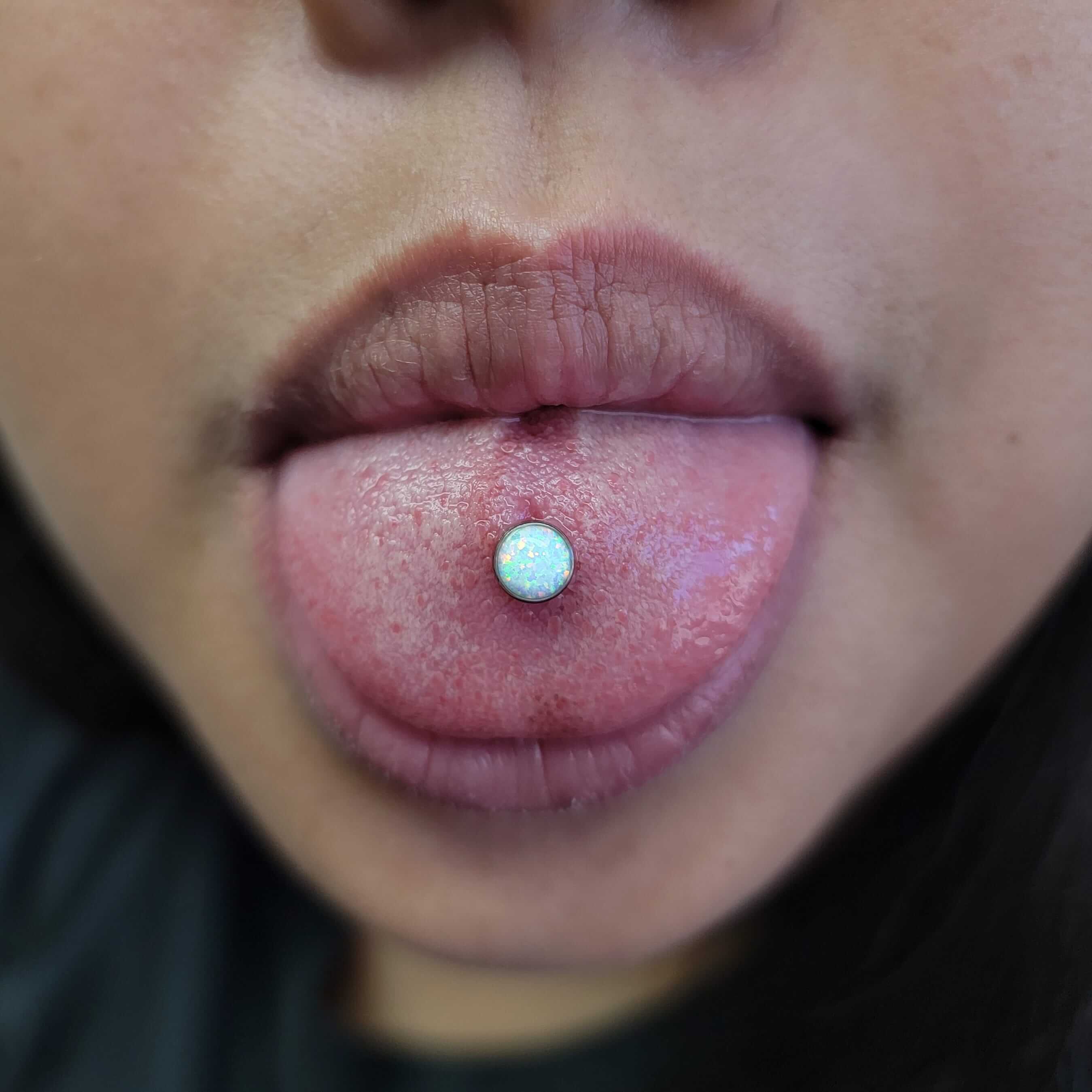 Tongue piercing done with implant grade titanium and white opals