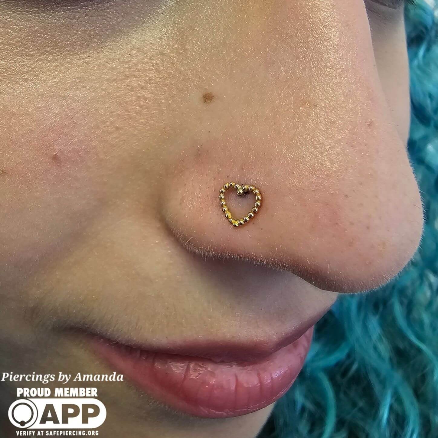 Fresh nostril piercing with a 14k rose gold heart